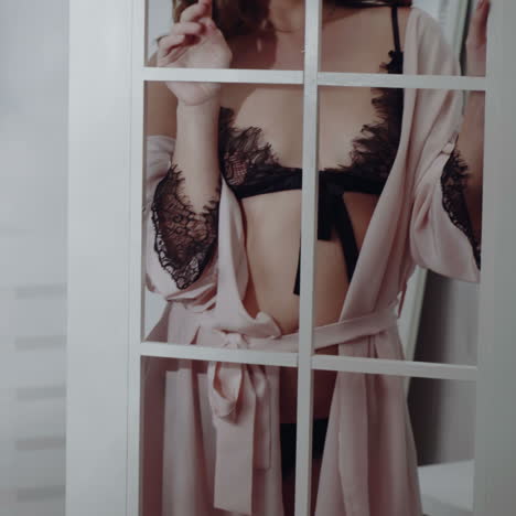 elegant brunette girl in black sexy lingerie and pink shirt posing. perfect body. glamor. fashion.