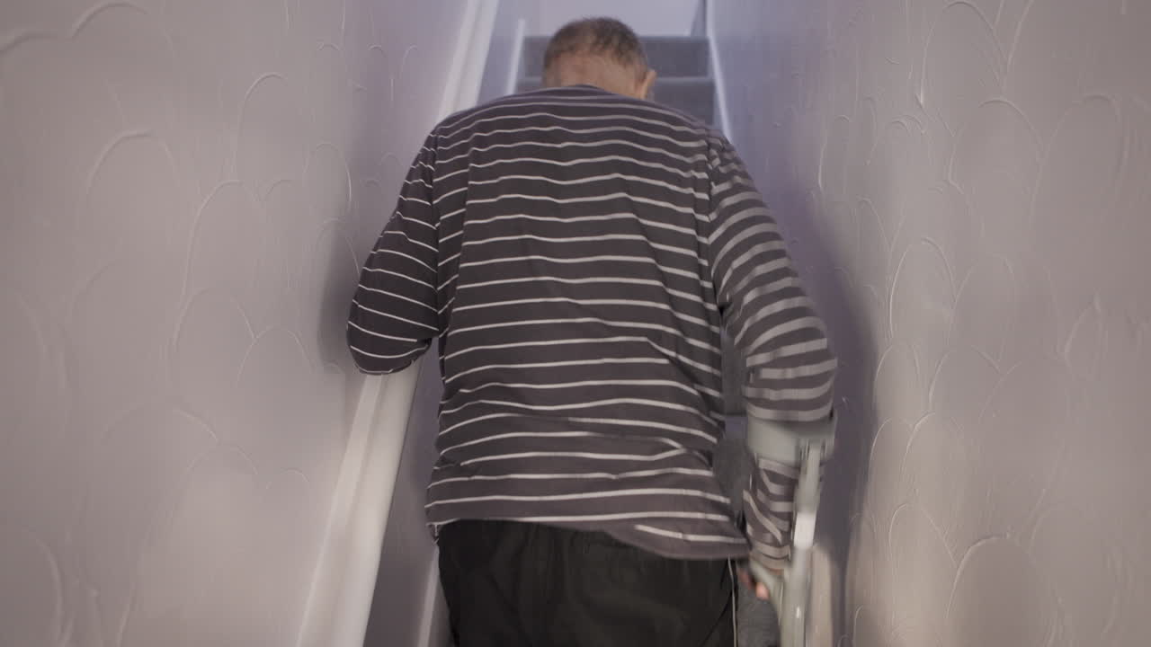 Man using crutches on stairs