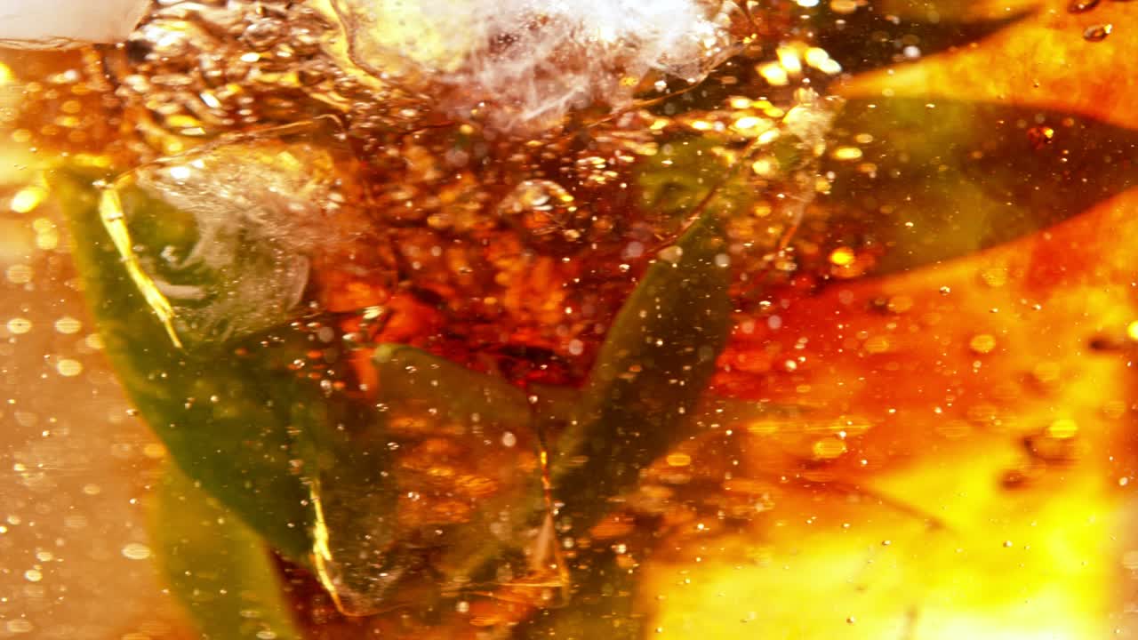 회전하는 물에서 잎과 검은 차를 혼합하는 슈퍼 느린 모션