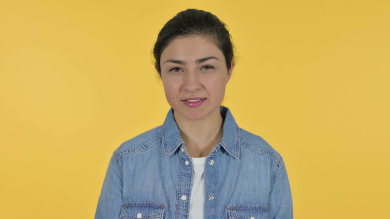 Sejrstegn af ung indisk kvinde, gul baggrund