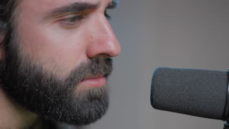 hombre cantando en el micrófono en el estudio de grabación