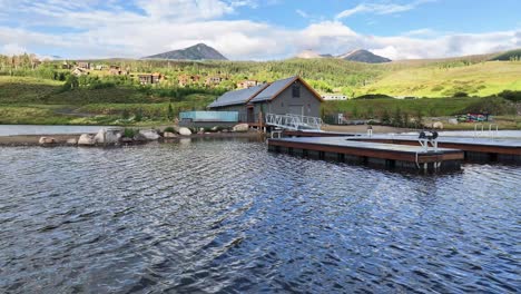 boat house lake house with a boat dock on a lake with buffalo mountain in the background located in silverthorne colorado aerial orbit