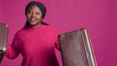 woman carrying two pieces of luggage