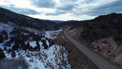 Toma-Aérea-De-Drones-De-Una-Carretera-Tranquila-Que-Se-Dobla-Entre-Dos-Montañas