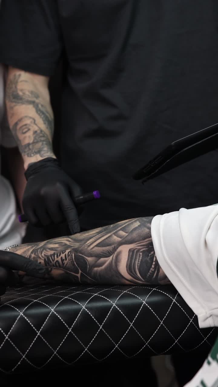 Tattoo Artist Examining a Client's Detailed Tattooed Arm