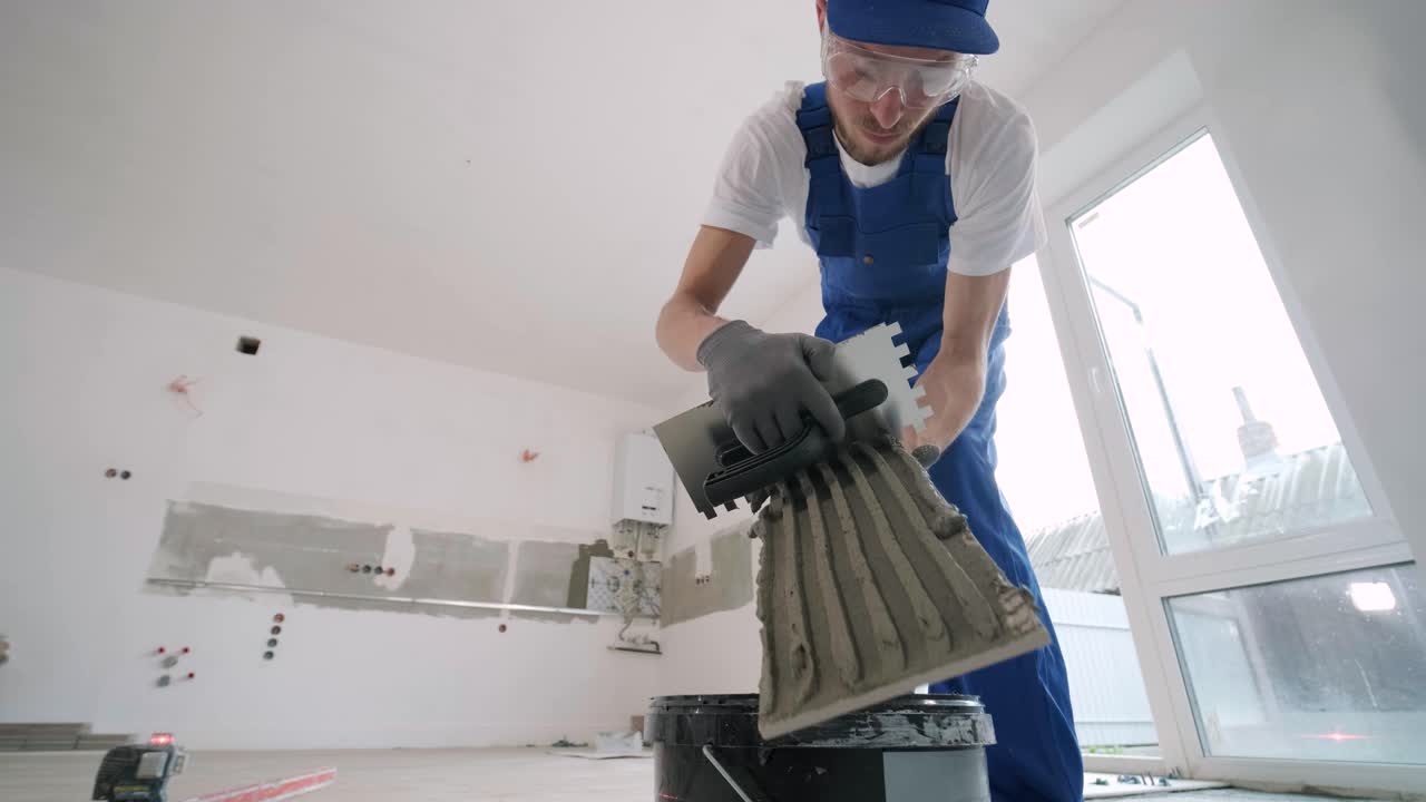 Installing ceramic floor tiles - measuring and cutting the pieces. Construction, renovation, repair apartment. Cuts tile. Tile cutting