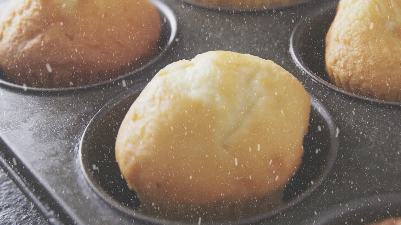 Baking golden muffins with flour dusting in metal tray in kitchen