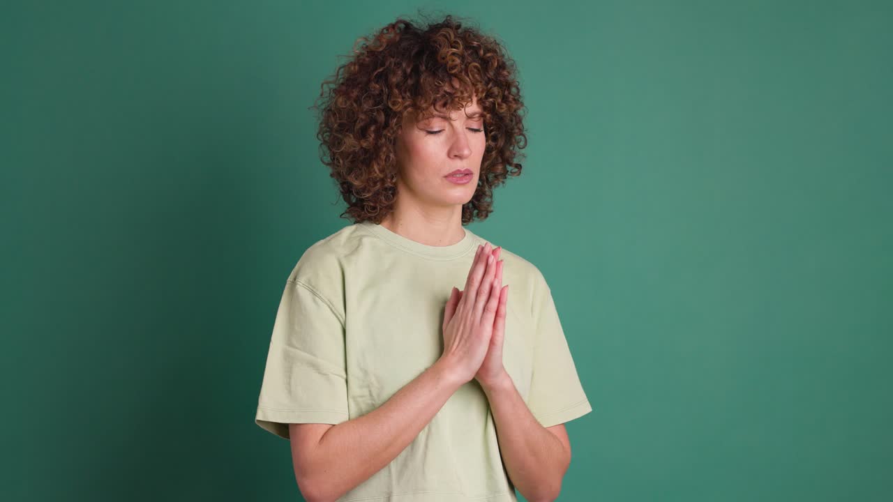Woman praying with closed eyes to God asking for blessing, help, forgiveness