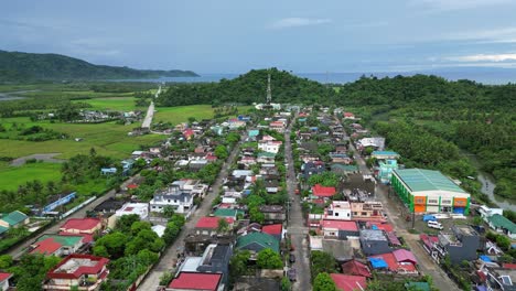 establishing aerial view of idyllic, tropical town within lush jungle outskirts of catanduanes, philippines