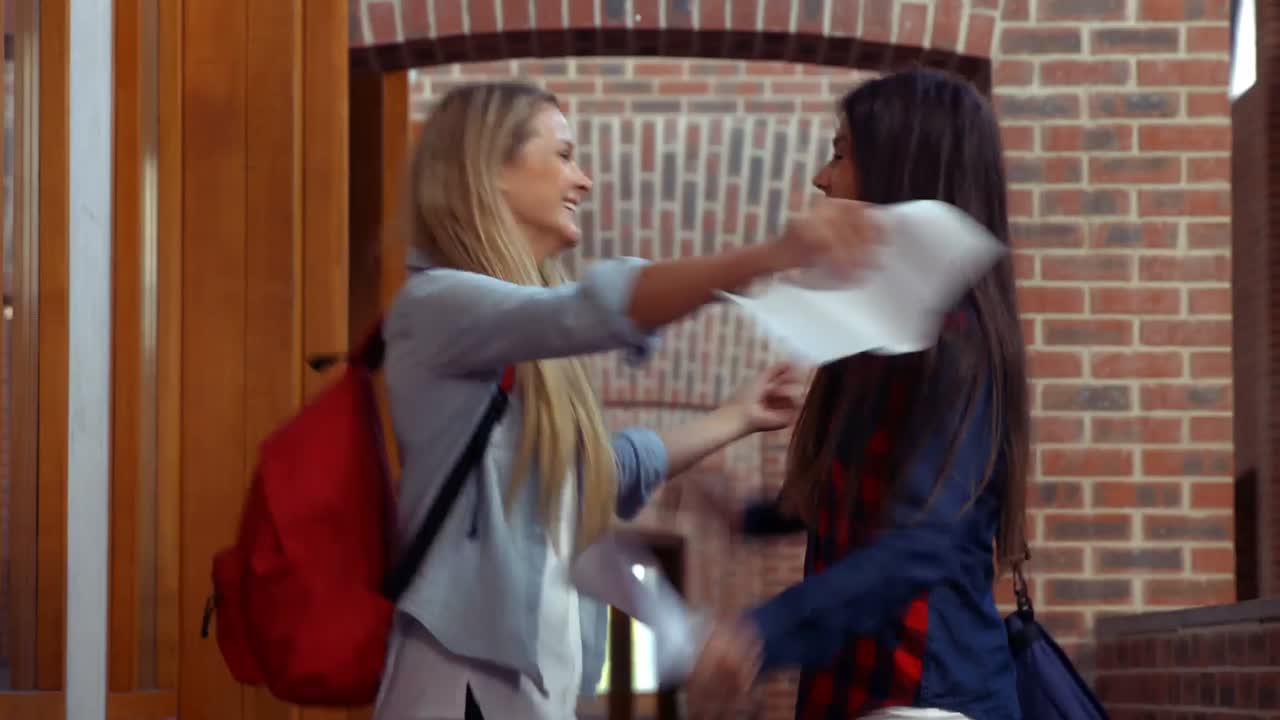 두 명의 흥분 된 학생 들 이 결과 를 보고 있습니다.