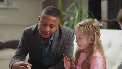 Teacher-shows-cards-telling-objects-names-to-girl-at-lesson