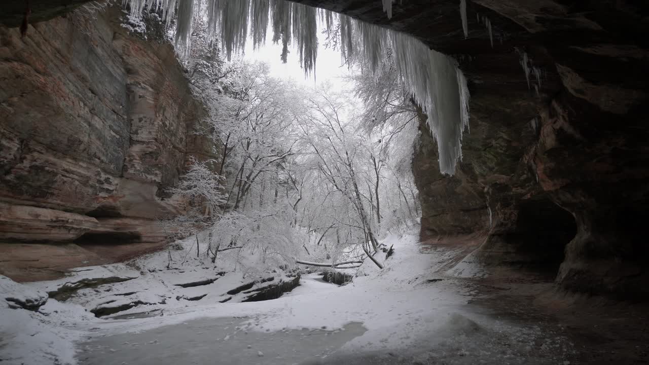 dentro de la cueva, nieve cayendo fuera de la entrada de la cueva, concepto de aventura
