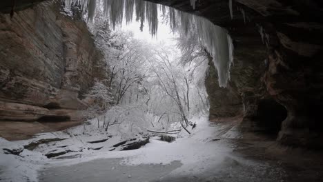 inside cave, snow falling outside cave entrance, adventure concept