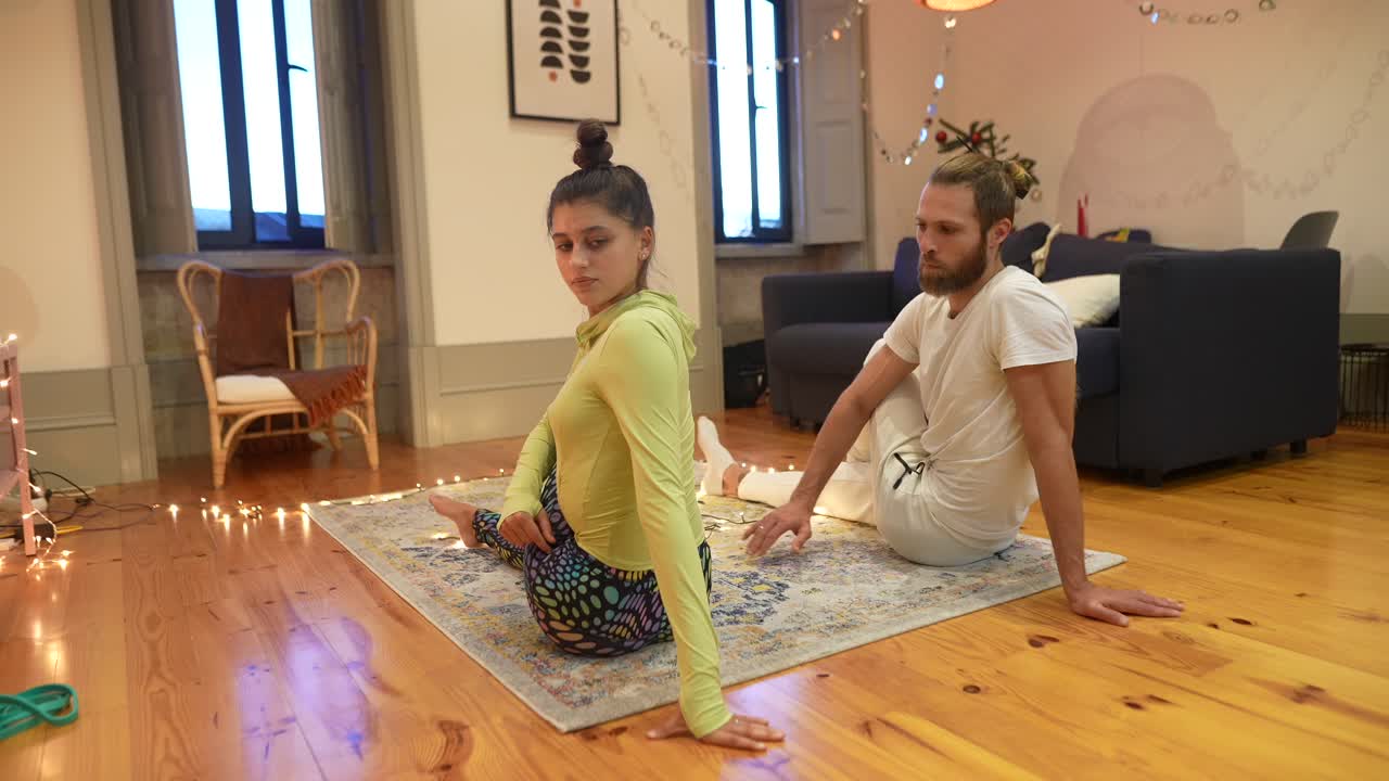 pareja practicando yoga en casa
