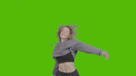 studio shot of young woman having fun dancing against green screen 15