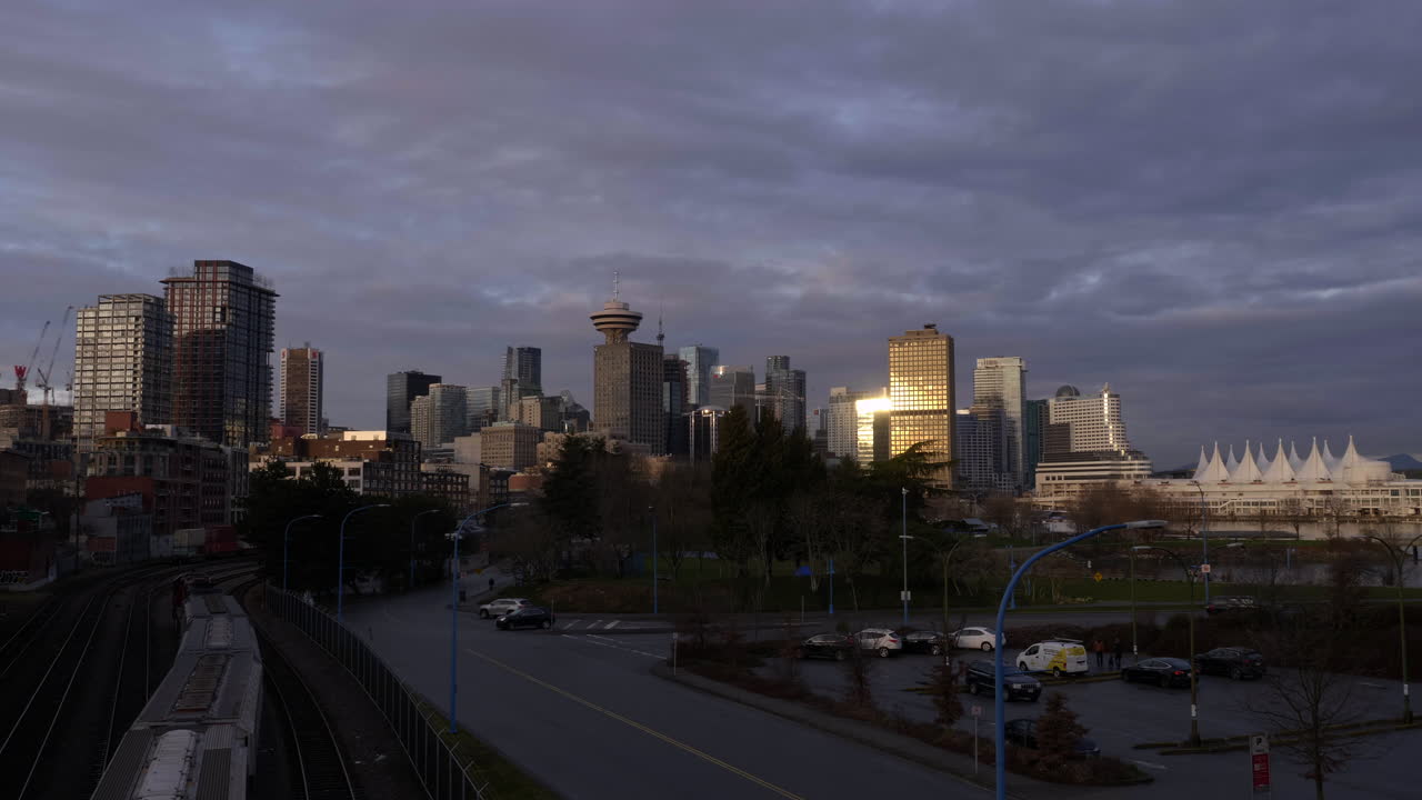 los vehículos pasan por la autopista desde temprano en la mañana hasta el amanecer en gastown, vancouver, canadá
