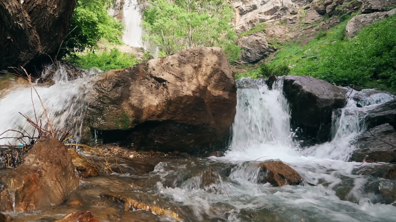 el agua neta de la red del río pequeño fluye en piedra en primavera