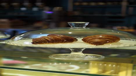 fresh croissants in a glass display case