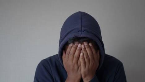 man hiding face in hoodie