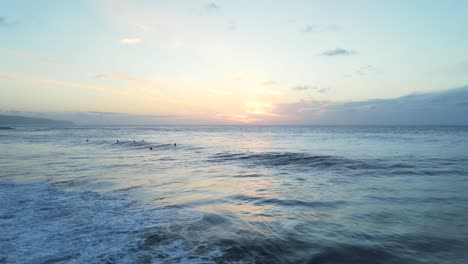 Surfers-Waiting-For-The-Next-Wave-At-Sunset,-North-Shore-Oahu,-Hawaii