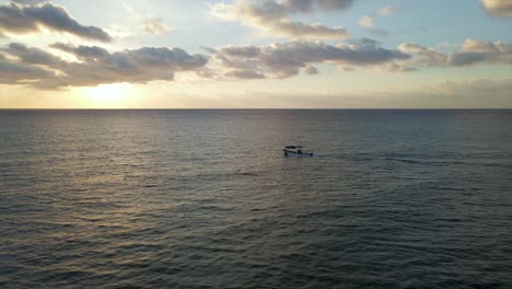 Lancha-Rápida-En-El-Océano-Pacífico-De-México-Con-Puesta-De-Sol-En-El-Horizonte,-Seguimiento-Aéreo-Con-Espacio-De-Copia