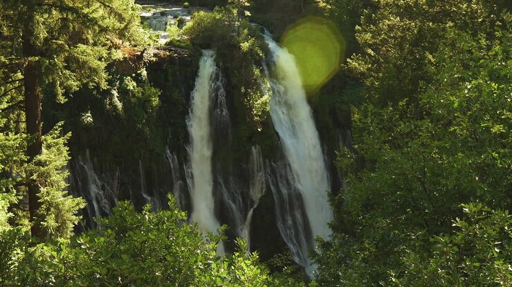 Valle con cascata che si riversa nella pozza, splendida vista del fiume e della foresta in lontananza