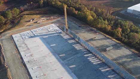 una foto de un dron sacacorchos de una grúa pesada que levanta un panel de hormigón hasta su lugar de descanso final