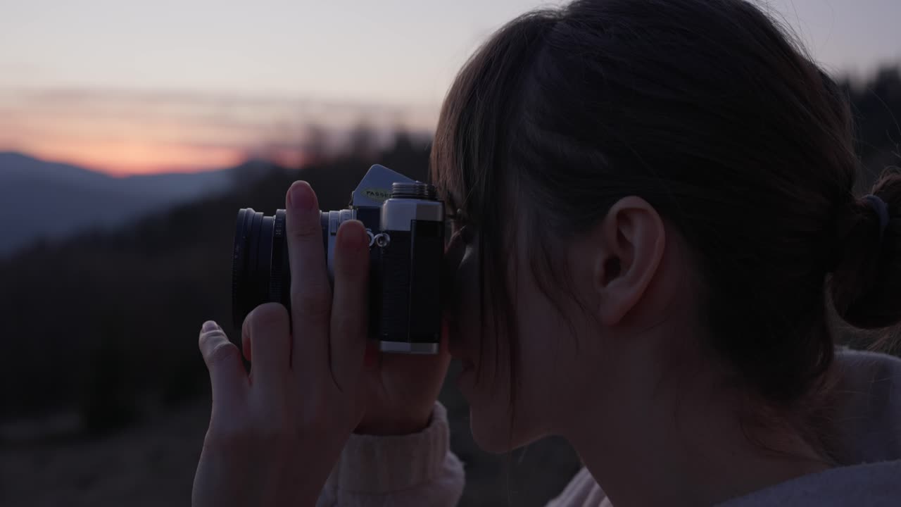 Woman taking photos at sunset