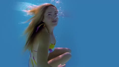 pretty blonde swimming towards camera and smiling