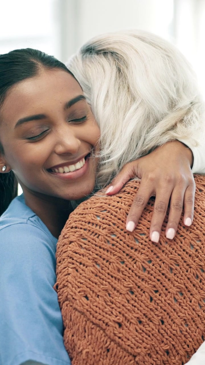 Young Nurse Embracing Senior Woman in Care Facility