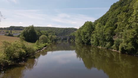 Aerial-approach-towards-an-old-train-trestle-that-connects-the-two-banks-of-the-Sieg-in-west-Germany-on-a-sunny-spring-day