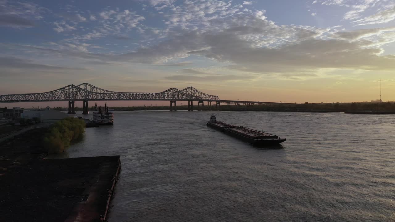 일출 때 미시시피 강에서 바지선을 밀고 있는 푸시보트