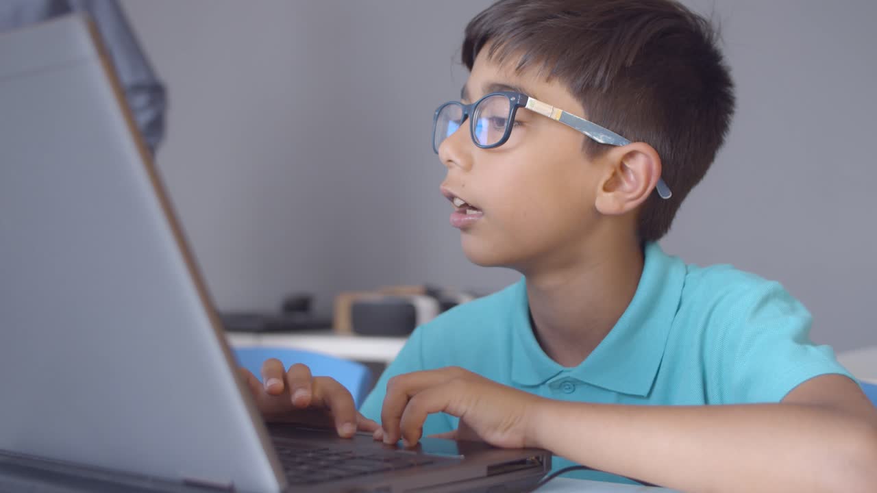 niño de escuela centrado sentado en el escritorio en el aula