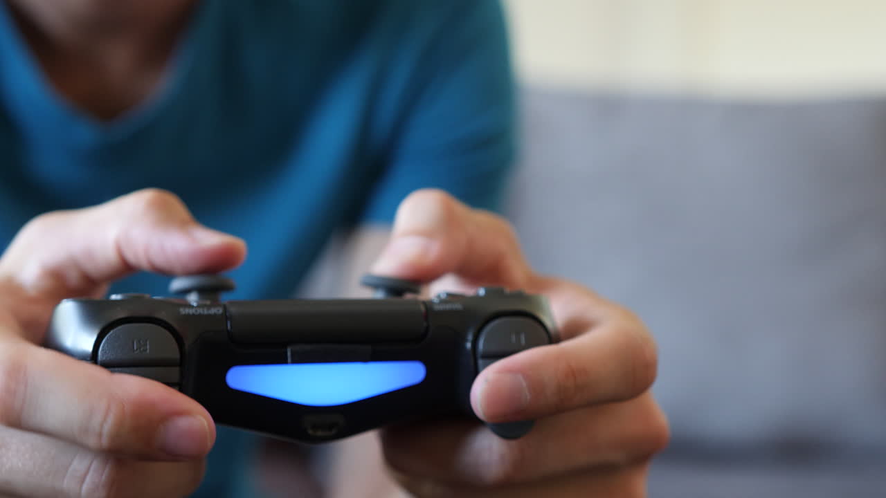 giovane che gioca a un videogioco su un divano, primo piano del controller