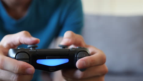 Junger-Mann-Spielt-Ein-Videospiel-Auf-Einer-Couch,-Nahaufnahme-Des-Controllers