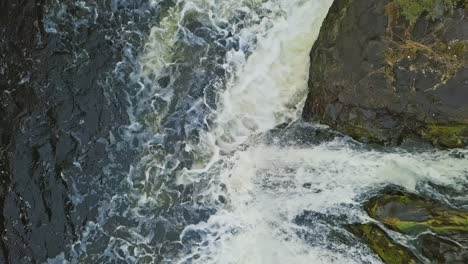full water stream with foam and rocks