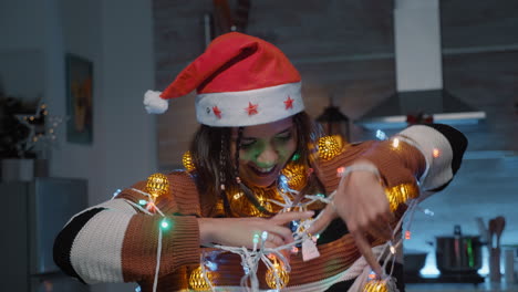 Mujer-Festiva-Con-Gorro-De-Papá-Noel-Intentando-Desenredar-Las-Luces.