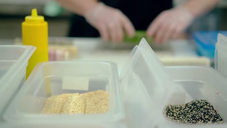 defocused cu cook prepares a japanese roll with rice and sesame seeds