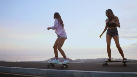 slow-motion footage captures two friends skateboarding on a road at sunset, with mountains and a stunning sky forming the backdrop. they're wearing shorts