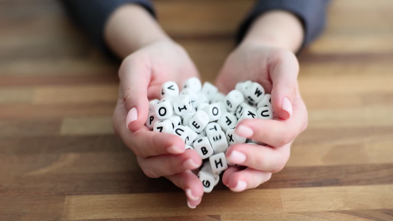 A pile of letter dice scattered on a wooden table