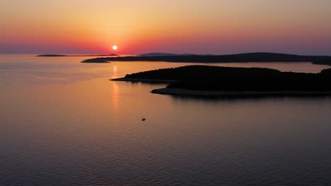 Puesta-De-Sol-Roja-Sobre-El-Agua-Con-Islas