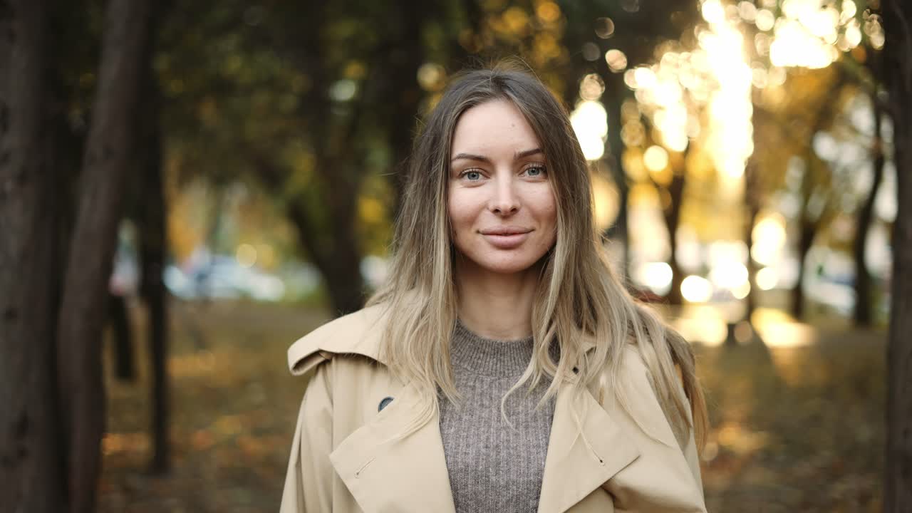 Relaxed woman between golden trees in calm sunlight on the background