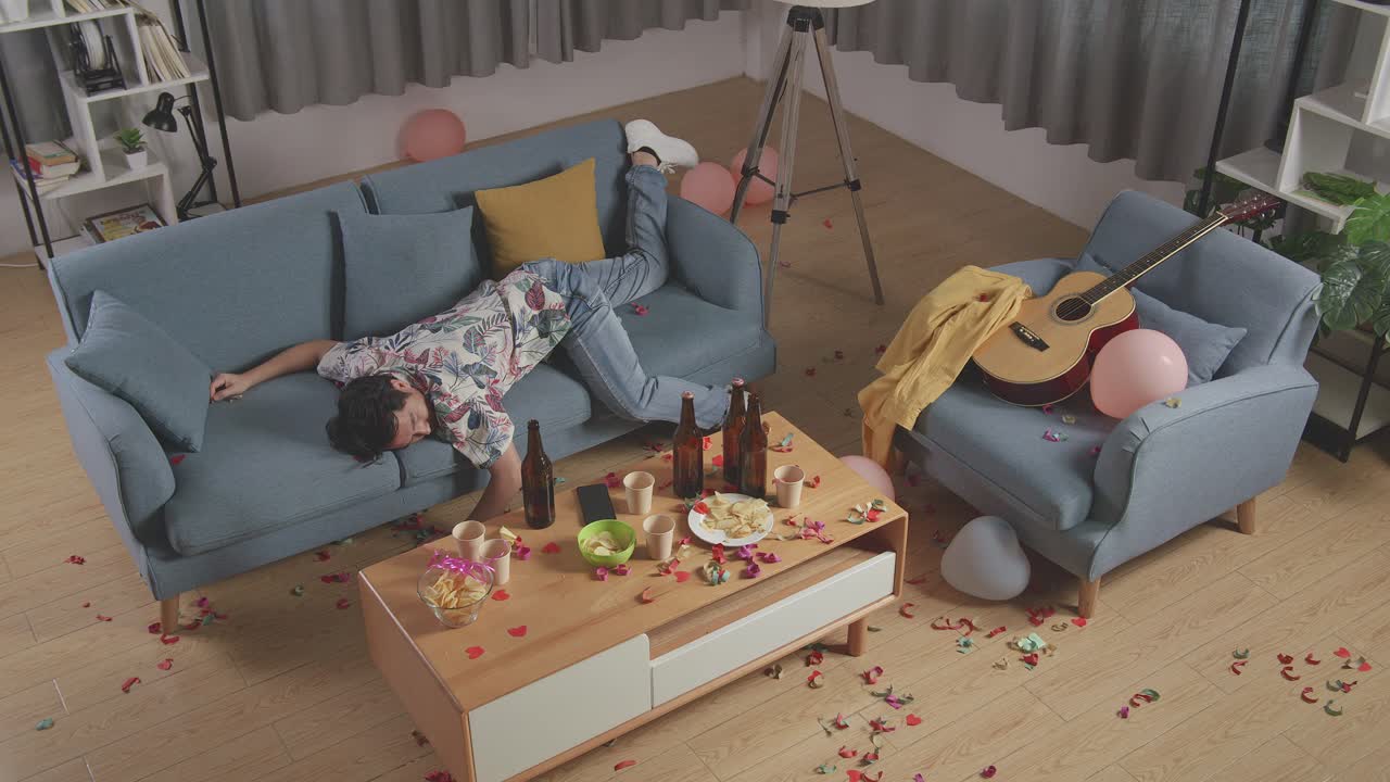 la fiesta salió mal. un hombre borracho durmiendo en el sofá.