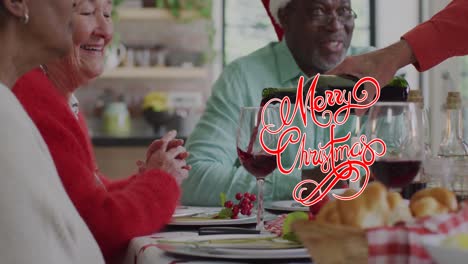 Animation-of-christmas-greetings-text-over-diverse-friends-at-christmas-meal-table