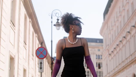 young elegant african woman walking down the street