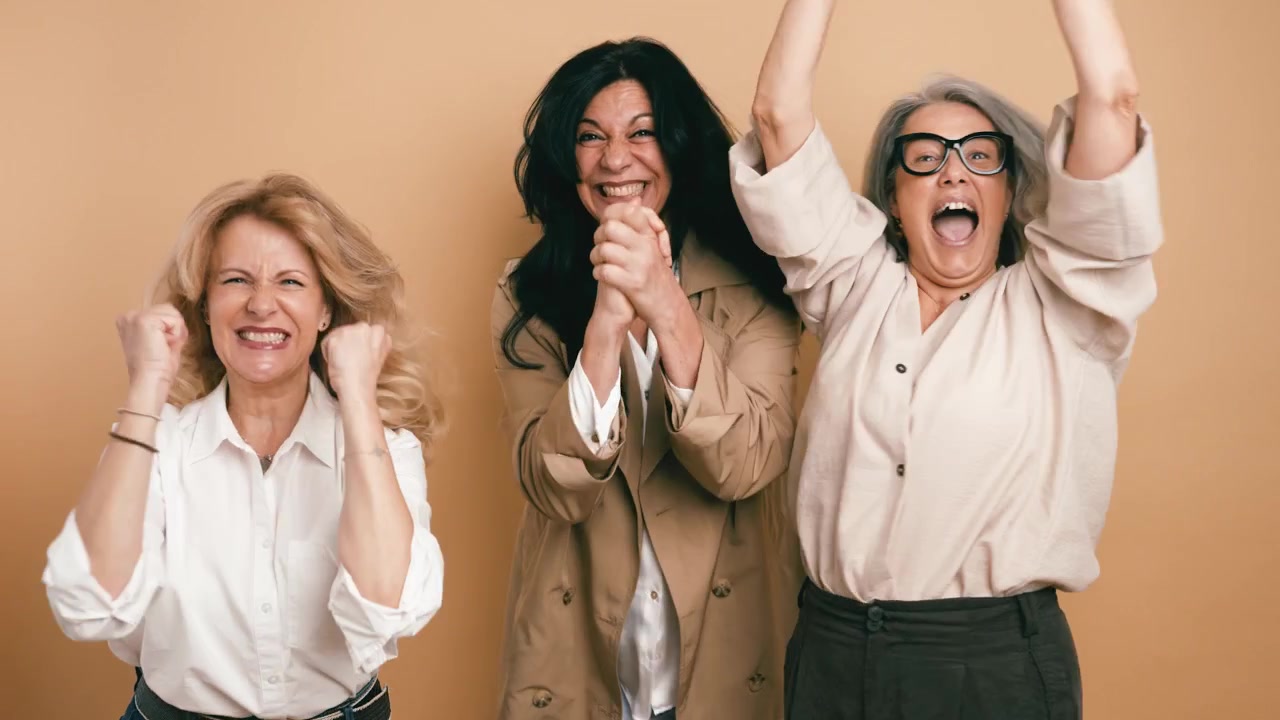 Tre donne mature che celebrano il successo e brindano insieme