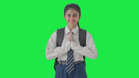 chica de la escuela india feliz haciendo namaste pantalla verde