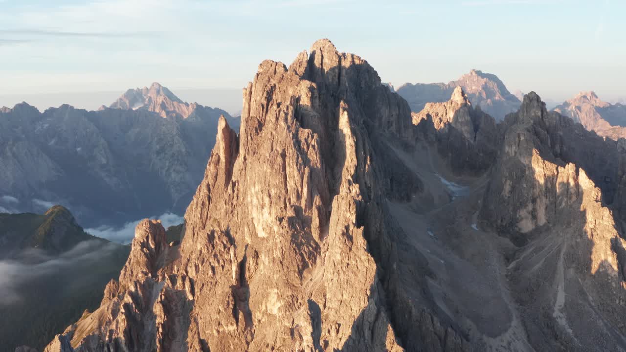 Primo piano con drone mentre i primi raggi dell'alba colpiscono le cime dei Cadini di Misurina, Italia