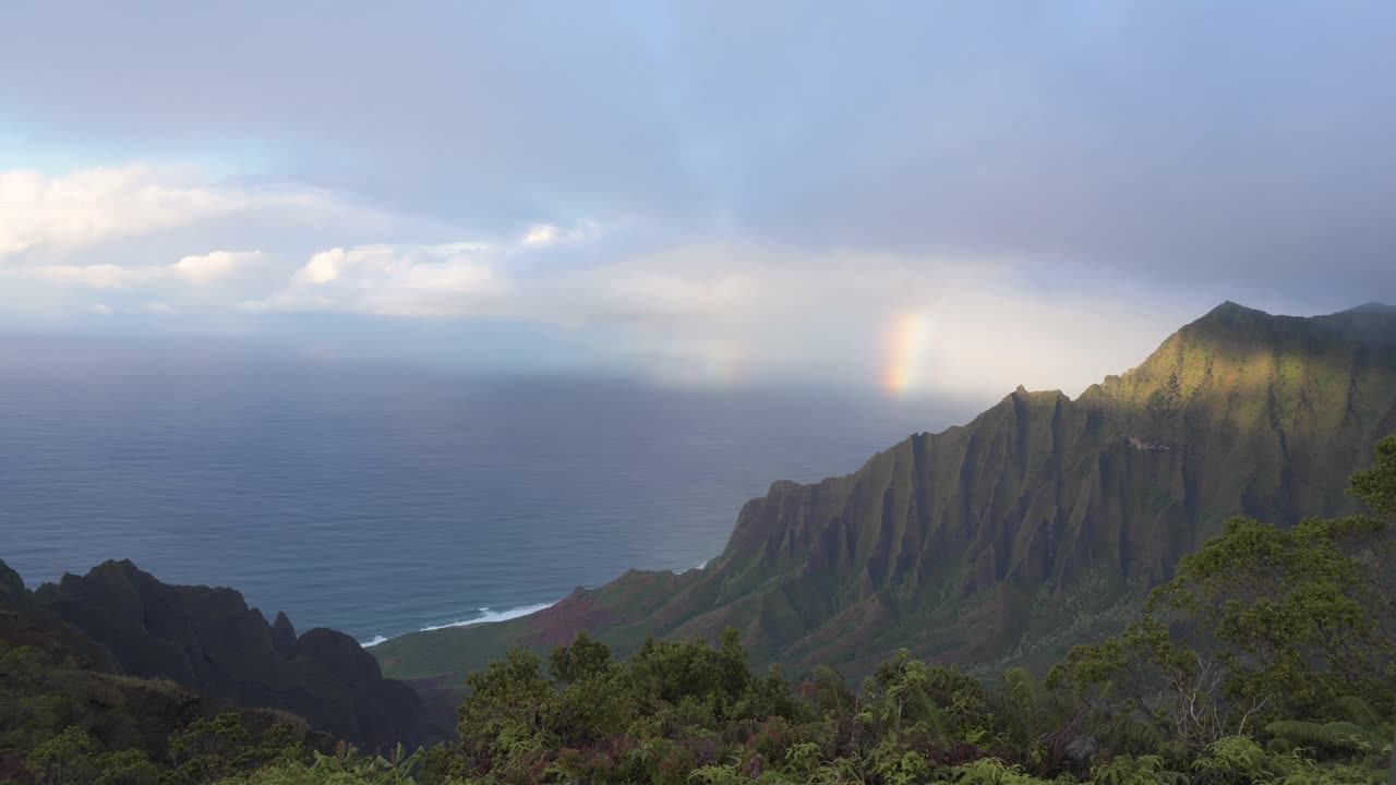A time-lapse of clouds moving and a rainbow appearing over the Kalalau Ridge on Kauai.
