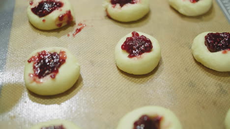 galletas de azúcar rellenas de mermelada sin cocer en una bandeja para hornear